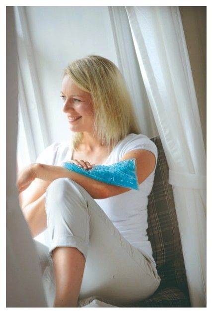 Woman Sitting by a Window With a Sports Pack on Her Arm