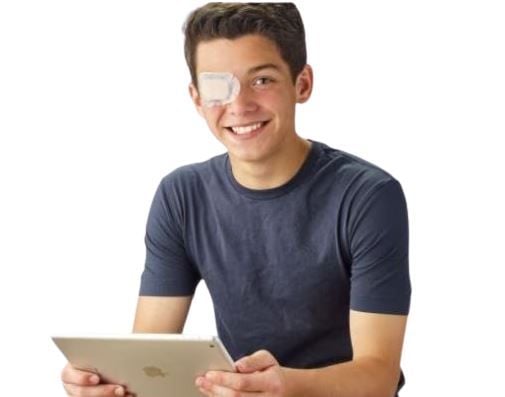 Boy Wearing Eye Patch While Holding Tablet