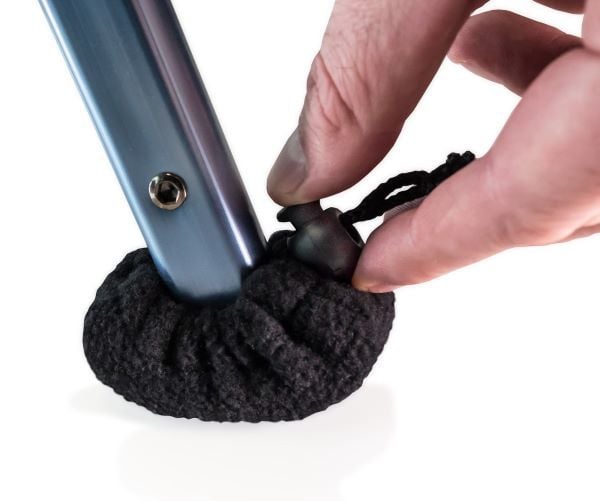 A user fastens the Ski Glide Sock Cover onto the walker's glide