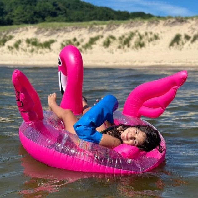 Girl on Flamingo-Shaped Tube Floating in a Lake While Wearing a Cast Protector