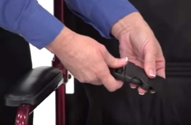 A caregiver buckles the seat belt