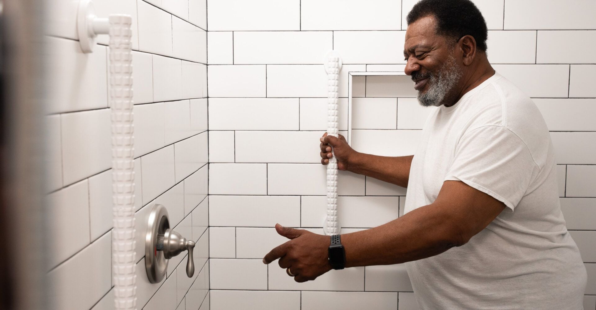 Man using white adjustable grab bar