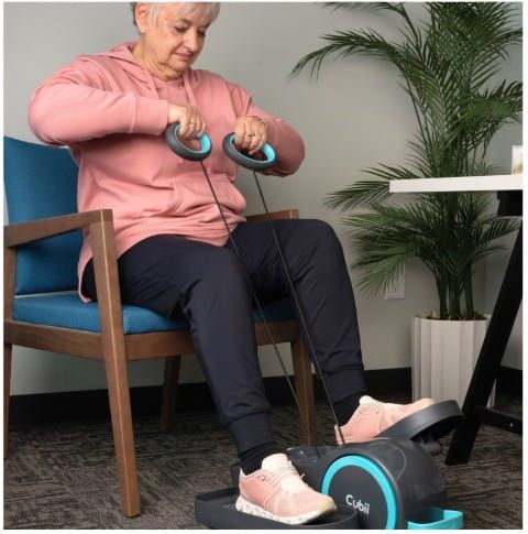 Woman sitting in a chair while using the Cubii