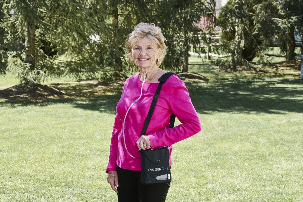 Woman standing outside with her Inogen Once G4 in its carrybag