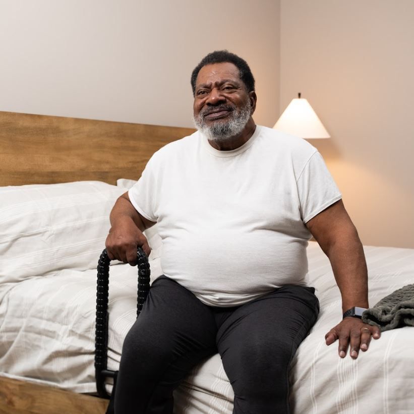 Man Sitting On Bed Next to MoveEasy SafetyGrip