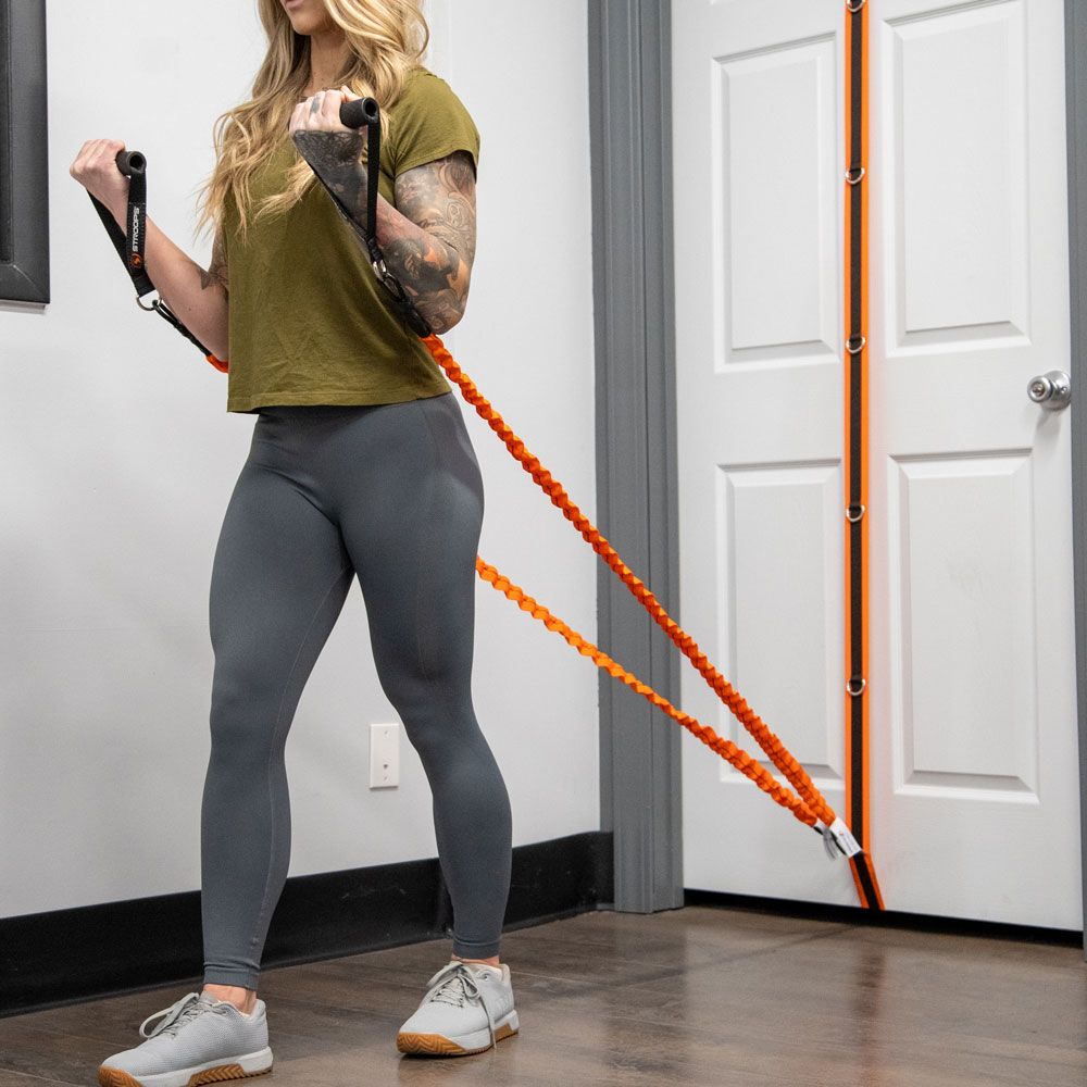 Trainer using orange resistance strap and grip handles