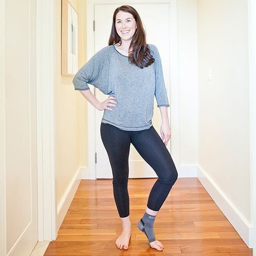 Woman standing in hallway, wearing Nice Stretch sleeve