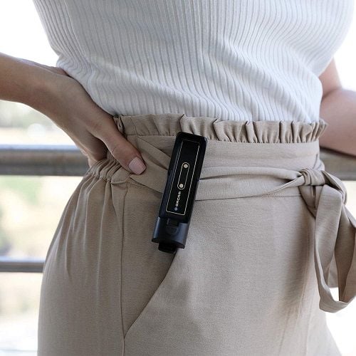 A woman wearing the OrCam MyCharger at her waist.