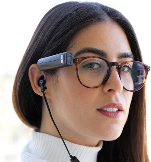 A woman wearing the OrCam Bluetooth headphones.