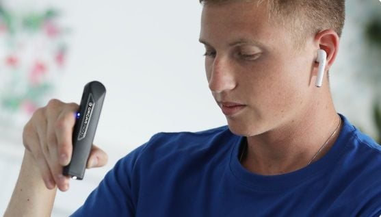 The OrCam Read in use with Bluetooth headphones.