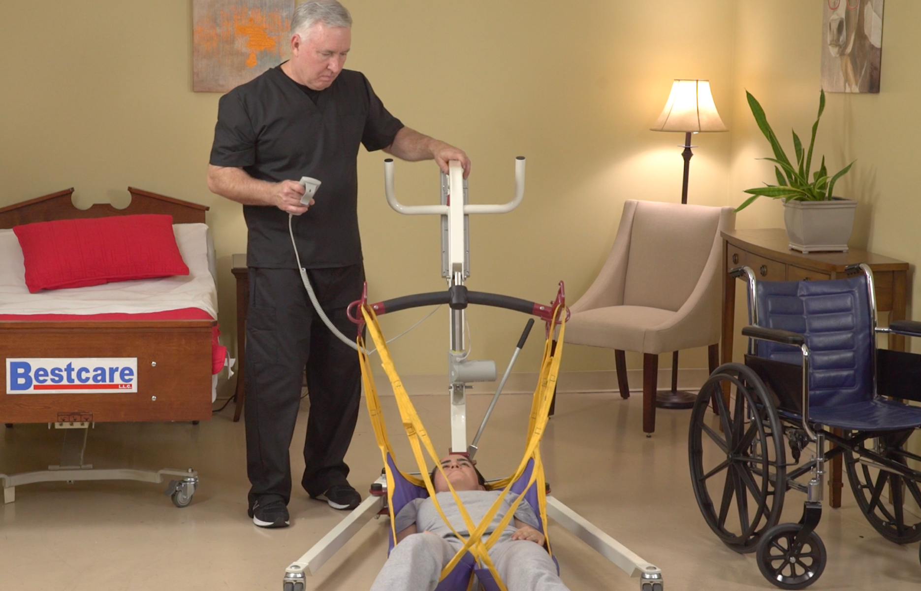 An older man using a lift to lift a young woman from the floor
