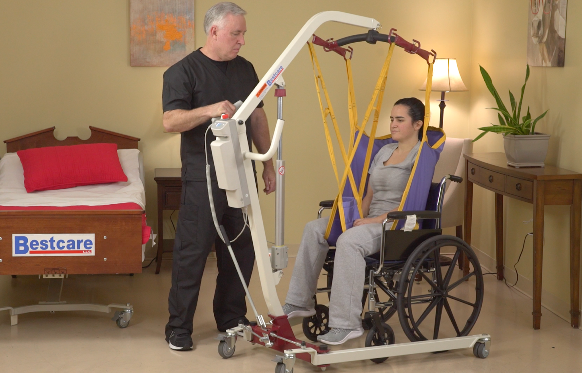 An older man using a lift to move a young woman in a wheelchair