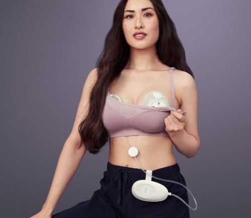 Woman using the breast pump under a standard nursing bra