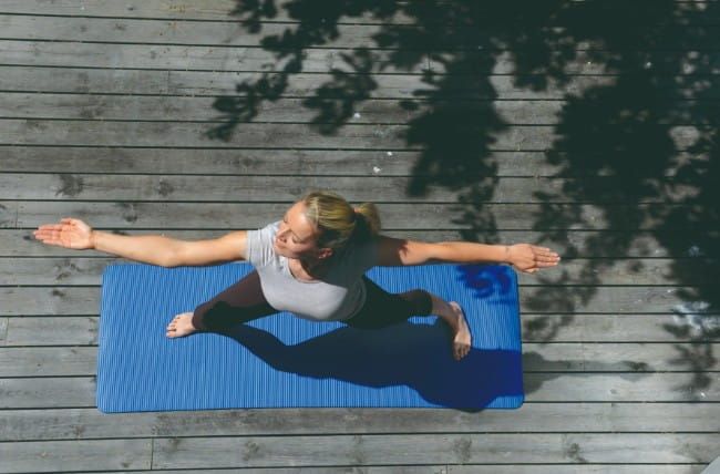 Aerial View of Woman in Warrior 2 Yoga Pose Standing on Mat