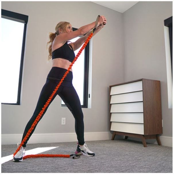 Woman Exercising in Room With Orange Resistance Bands