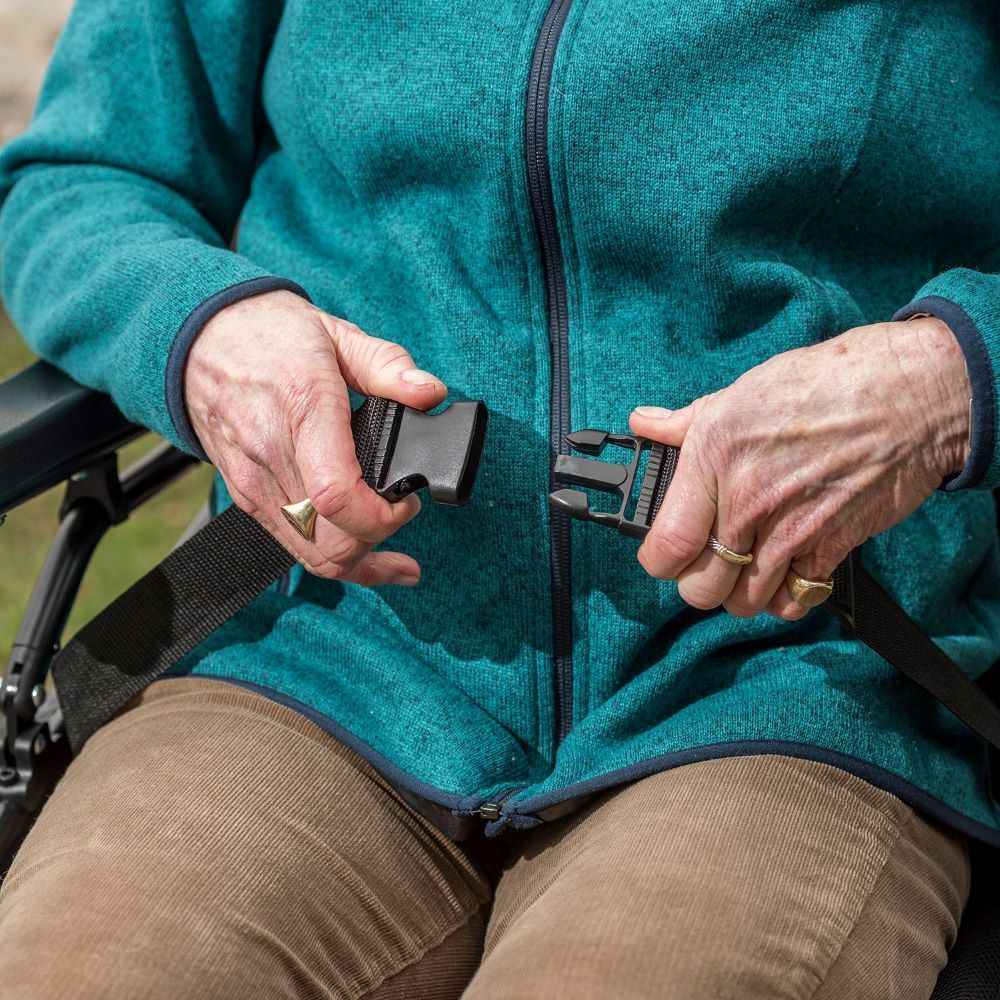 A woman using seatbelt of the So Lite Super Lightweight wheelchair