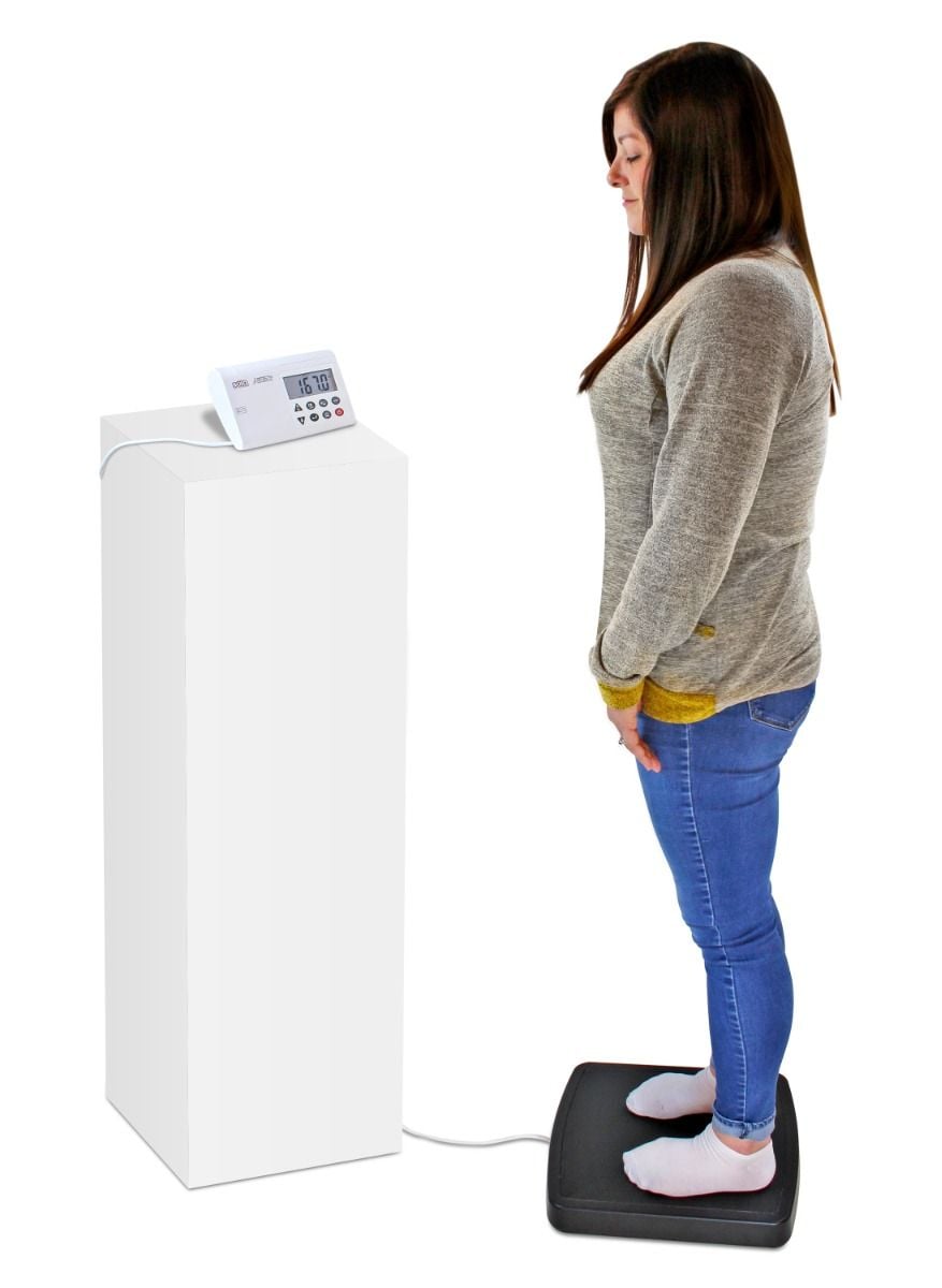 Woman using scale with display unit on pillar