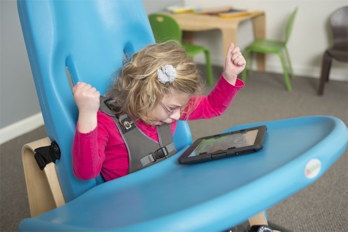 Little girl uses tablet on activity tray