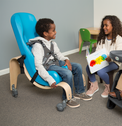 Little boy in soft-touch sitter reading a book with a little girl