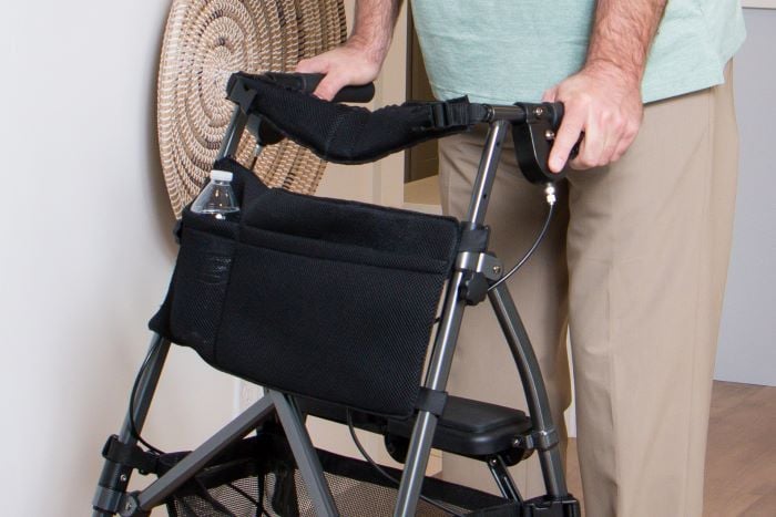 An EZ Fold-N-Go user pushes the walker with a Two Pocket Organizer Pouch (4303) holding a water bottle