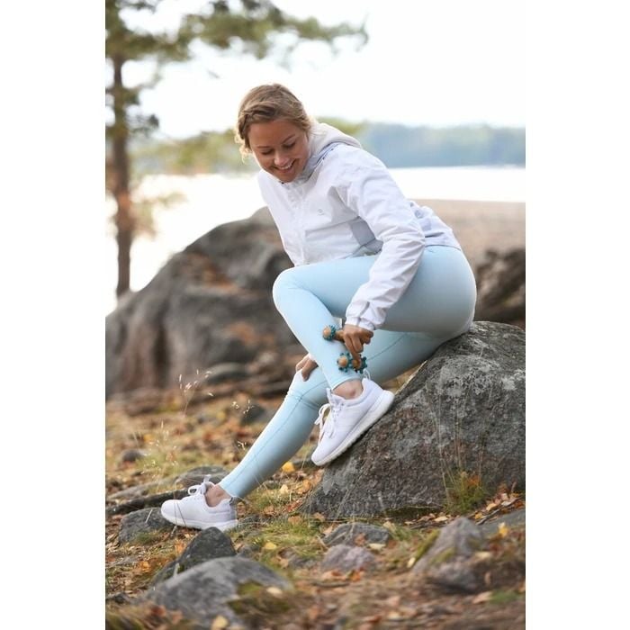 Woman in the outdoors using the Ergo-Roll on her leg
