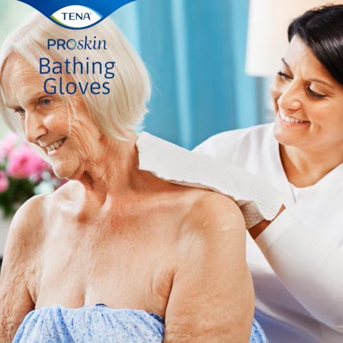 A caregiver using the glove on an elderly patient's shoulder.