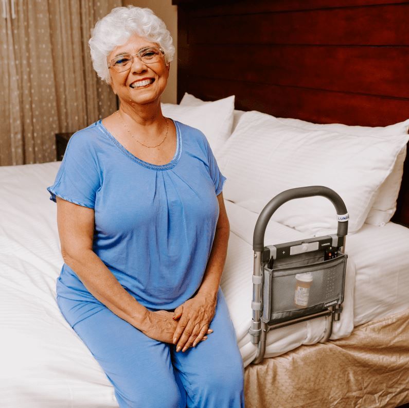 Woman Sitting in Bed Next to Bed Rail With Storage Bag