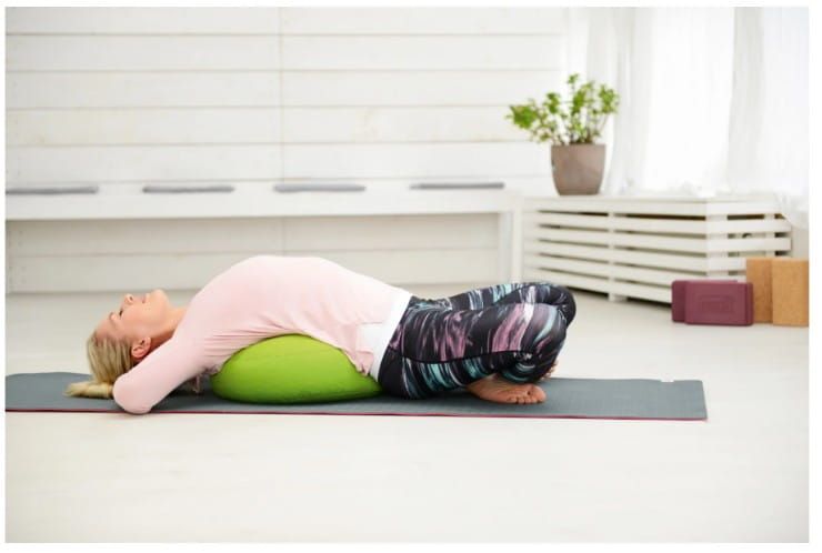 Woman Lying on a Cushion on a Yoga Mat