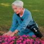 Lady Using Homefill While in Working in Flower Bed