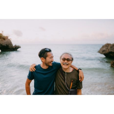 Lifestyle photo of son with dad who has the G5 inside carry bag at the ocean