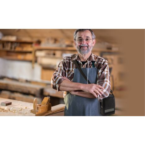 This lifestyle photo is of a man who is a carpenter in his woodshop and he is wearing his G5 carry bag over his apron. 