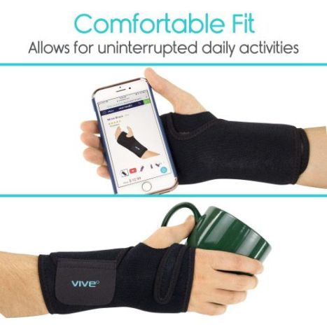 Someone wearing the Vive Brace while holding a cell phone and a coffee mug.