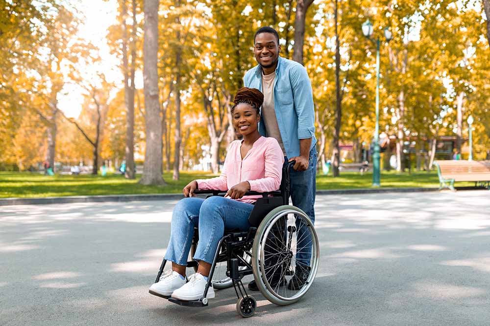 Man pushing woman in a wheelchair