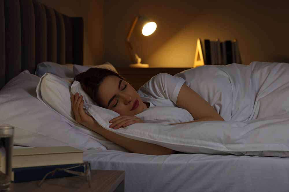 Adult woman sleeps peacefully in bed in a dark room