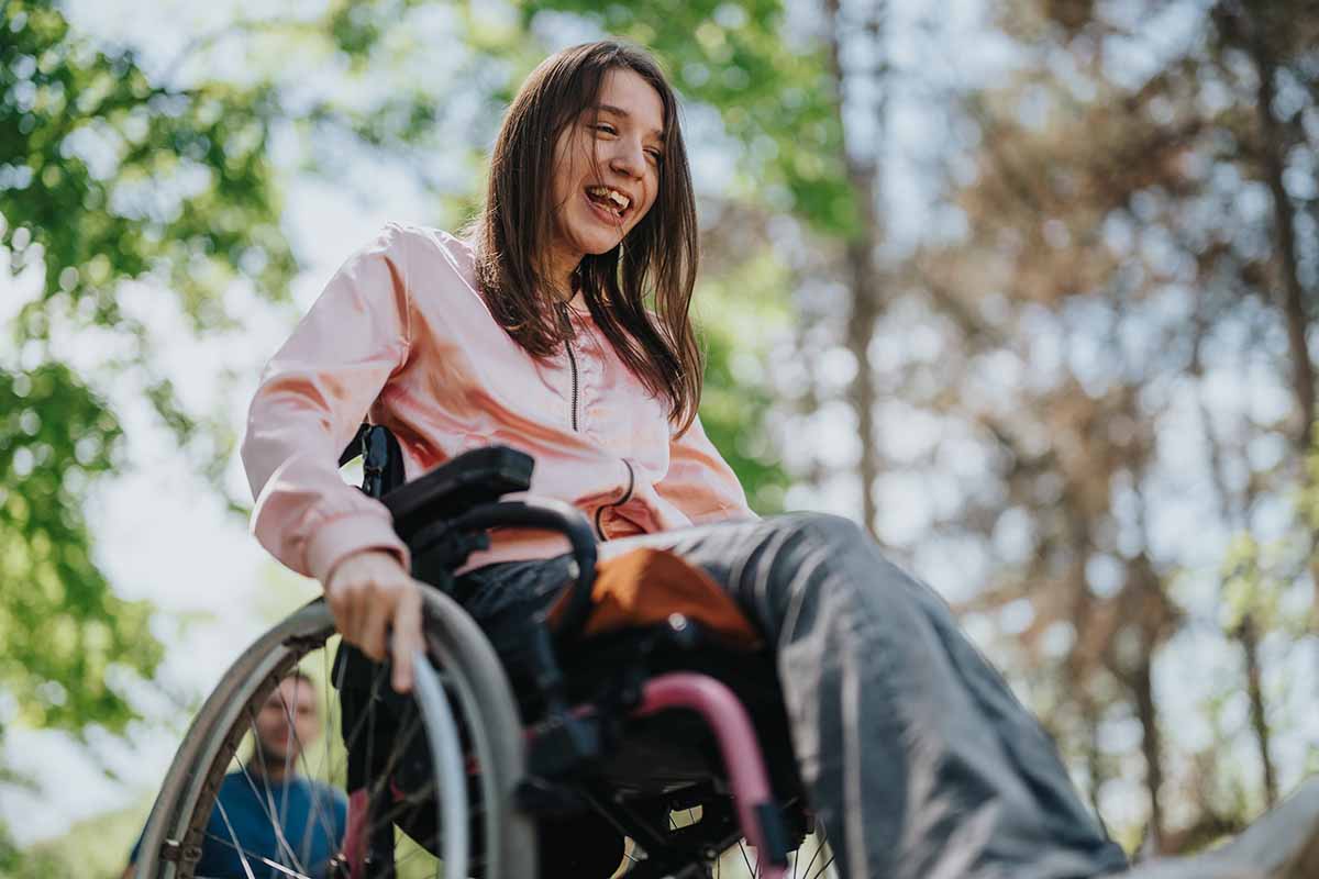 Young woman happily explores outdoors in a wheelchair
