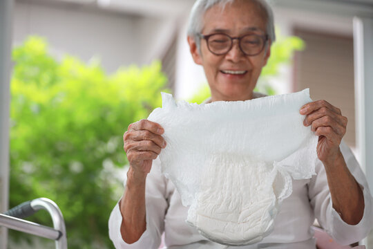 Older woman holding adult diaper