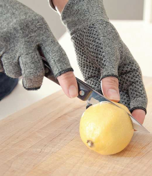Woman cuts vegetables with active gloves on.