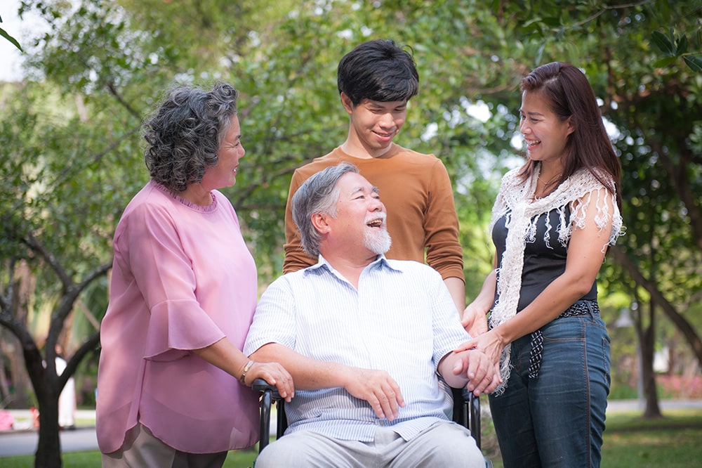 Family Surrounding Elderly Man in Wheelchair
