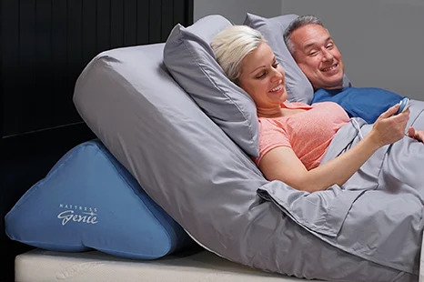 A couple uses the Mattress Genie to lie in an upright position