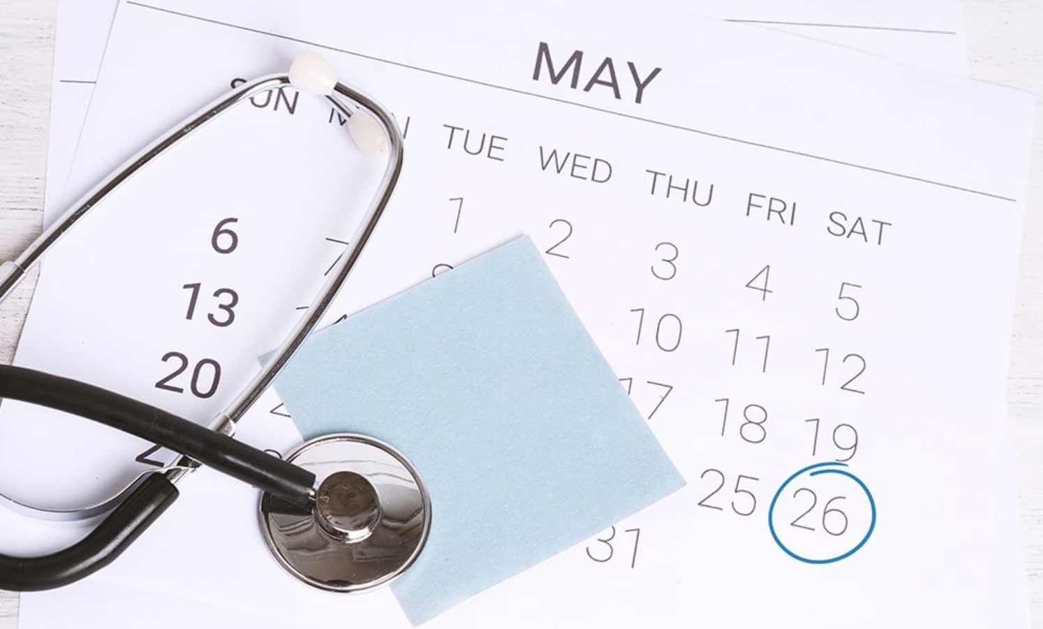 Calendar with stethoscope, sticky note, and circled date
