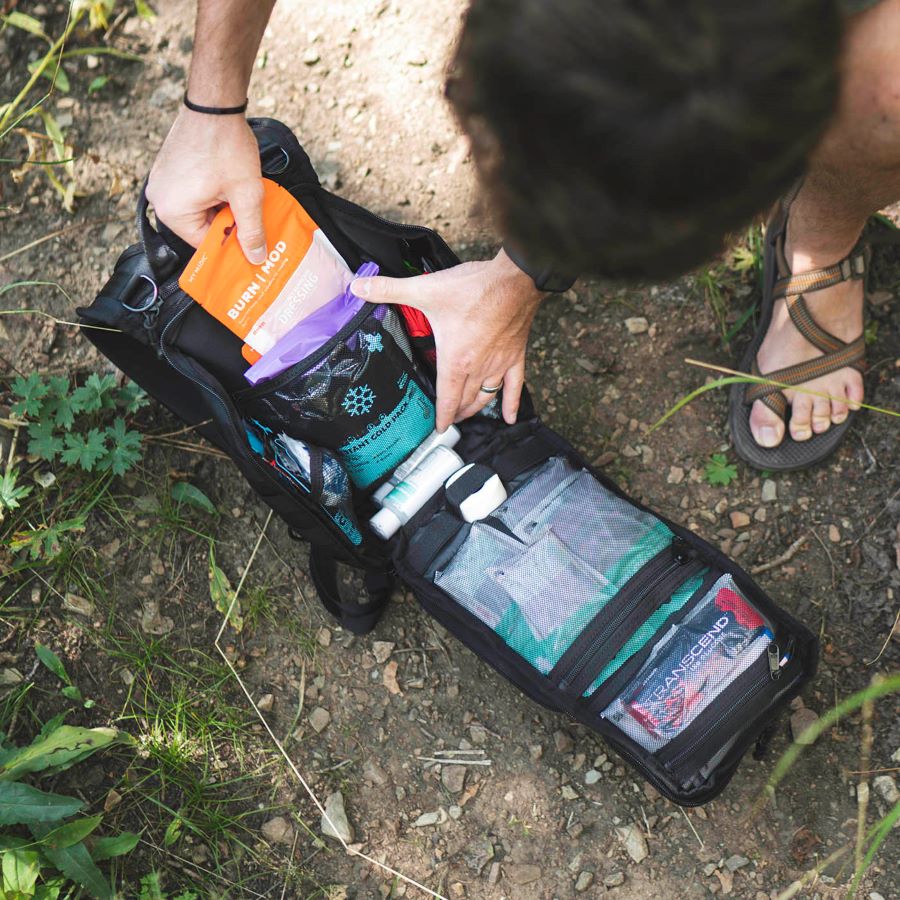 Man opening first aid kit while outdoors