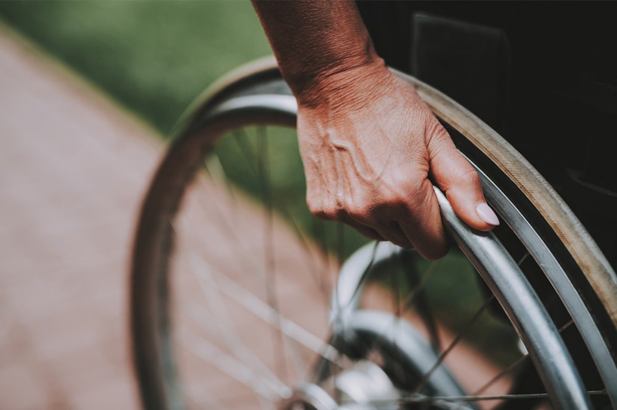 Woman's hand is shown as she pushes herself forward in a wheelchair
