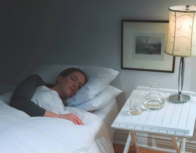 A woman sleeping on the Sound Oasis Therapy Pillow.