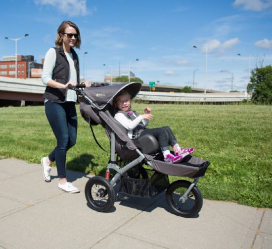 Woman pushing child in the scooter