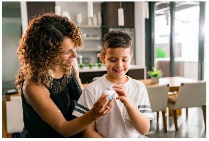 Mother Helping Son Use The Breather